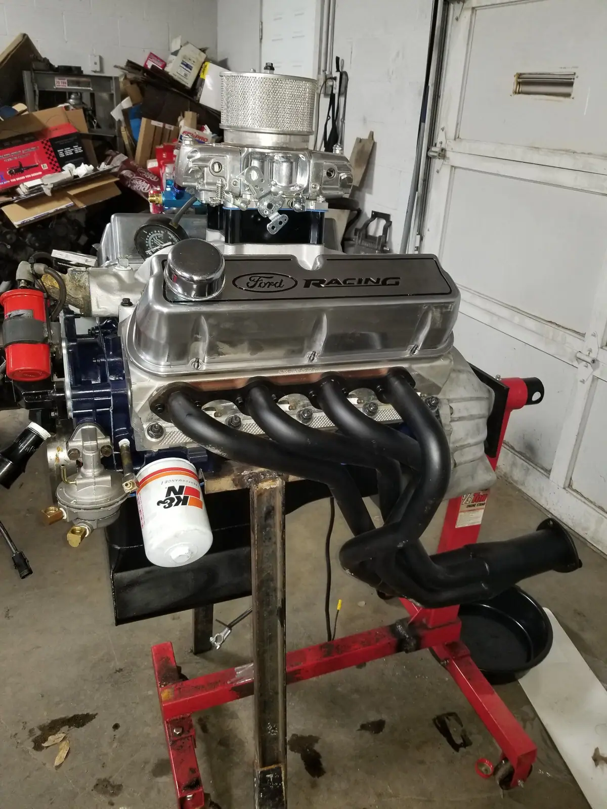 Ford Racing small-block V8 with black headers on an engine stand